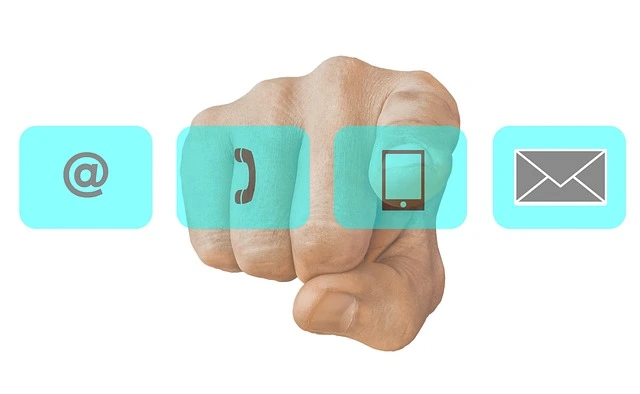 Icônes de contact représentant email, téléphone et message avec une main pointant vers eux, symbolisant la communication avec Gamma GT Santé pour toute question sur la santé hépatique.